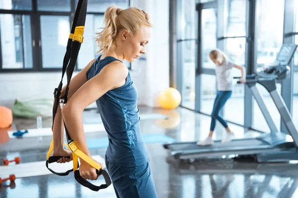 Blonde Fitness-Frau trainiert mit trx Fitnessbändern — Stockfoto