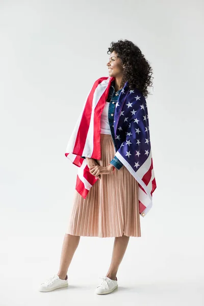 Mujer acurrucada con bandera americana - foto de stock
