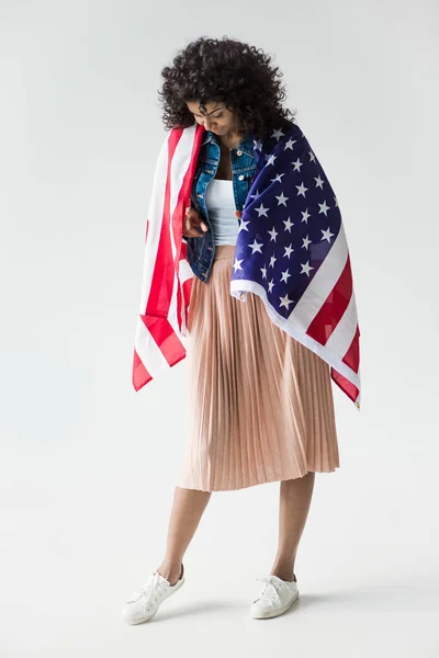 Mujer acurrucada con bandera americana - foto de stock