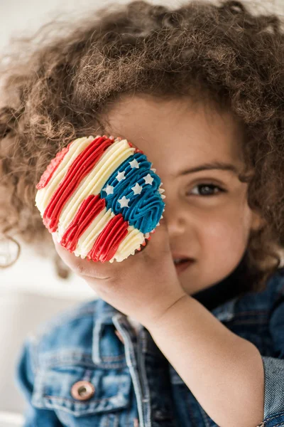Niña con panecillo de bandera americana - foto de stock