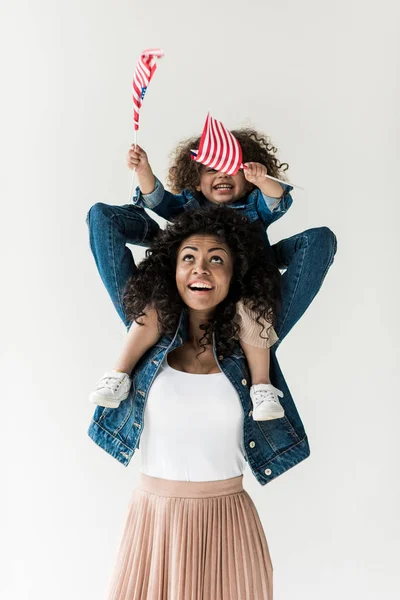 Hija sentada sobre hombros de madre - foto de stock