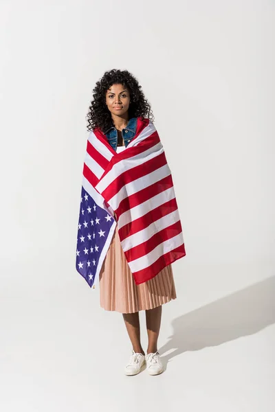 Mujer acurrucada con bandera americana - foto de stock