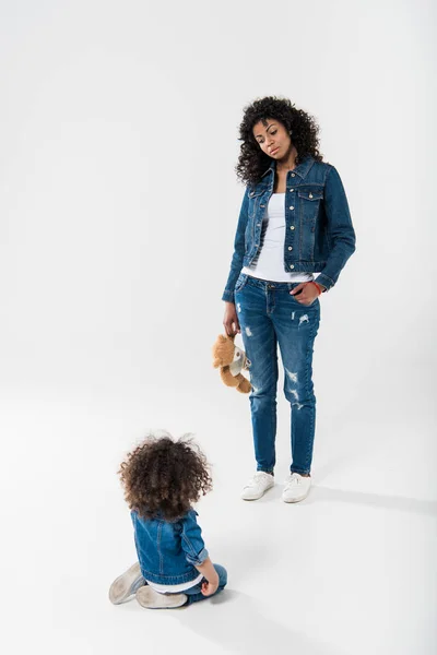 Мать с игрушкой стоя с дочерью — стоковое фото