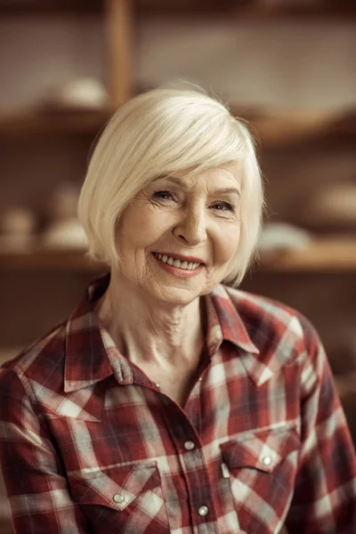 Porträt einer glücklichen Seniorin, die in die Kamera blickt — Stockfoto