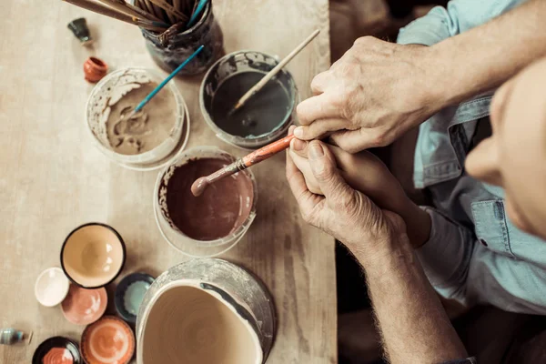 Mädchen malt Tontopf und Großeltern helfen bei Workshop — Stockfoto