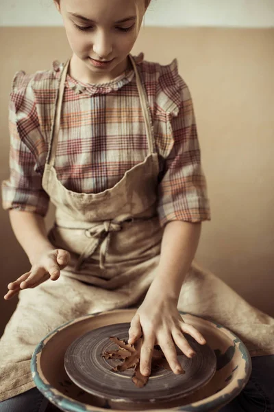 Front view of little girl making pottery on wheel at workshop — Stock Photo