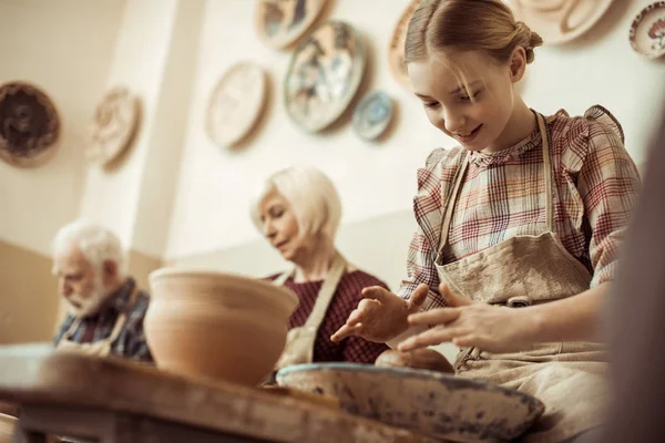 Grand-mère et grand-père avec petite-fille faire de la poterie à l'atelier — Stock Photo