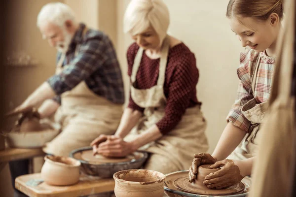 Grand-mère et grand-père avec petite-fille faire de la poterie à l'atelier — Stock Photo