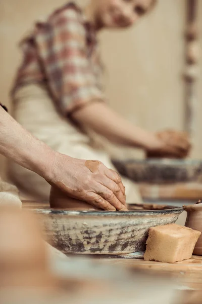 Primer plano de las manos femeninas trabajando en la rueda de alfarero - foto de stock