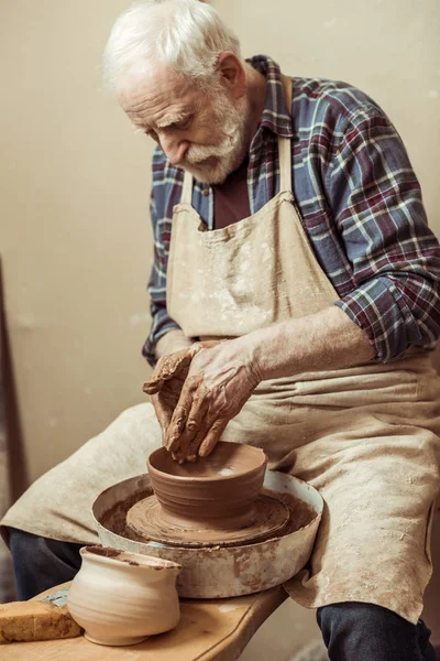 Primer plano del artesano masculino que trabaja en la rueda de alfarero - foto de stock