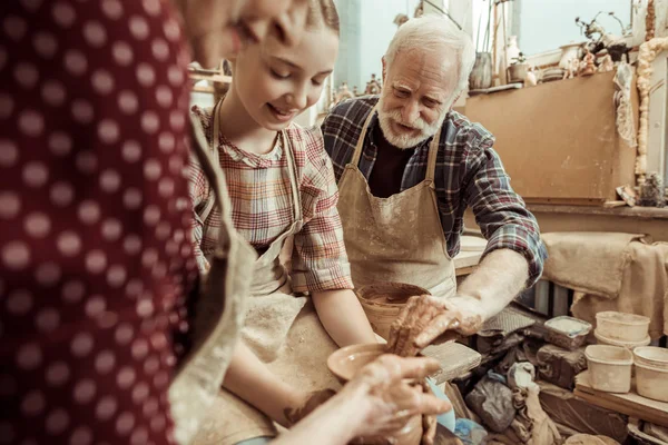 Grandmother and grandfather with granddaughter making pottery at workshop — Stock Photo