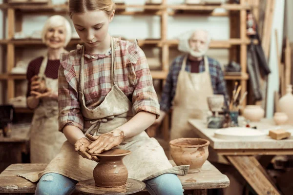 Grand-mère et grand-père avec petite-fille faire de la poterie à l'atelier — Photo de stock