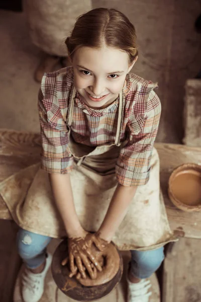 Vista aérea de la niña haciendo cerámica en la rueda en el taller - foto de stock