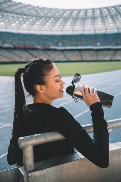 Sportswoman drinking water — Stock Photo