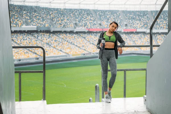 Sportswoman at handrail on stadium — Stock Photo