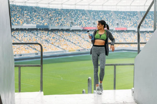 Sportswoman at handrail on stadium — Stock Photo