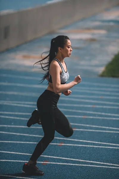 Спортсменка тренується на біговій доріжці — стокове фото