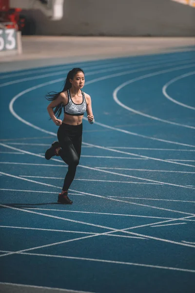Sportswoman training on running track — Stock Photo
