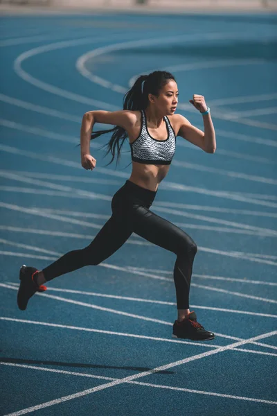 Sportlerin trainiert auf Laufstrecke — Stockfoto