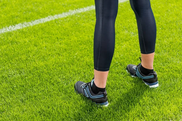 Sportlerin steht auf Rasen — Stockfoto