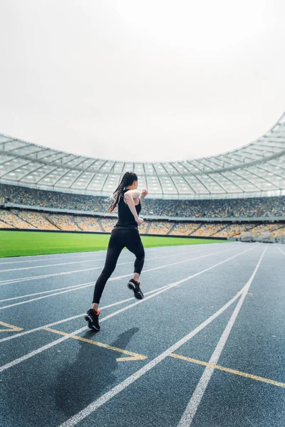 Sportlerin läuft auf Stadion zu — Stockfoto