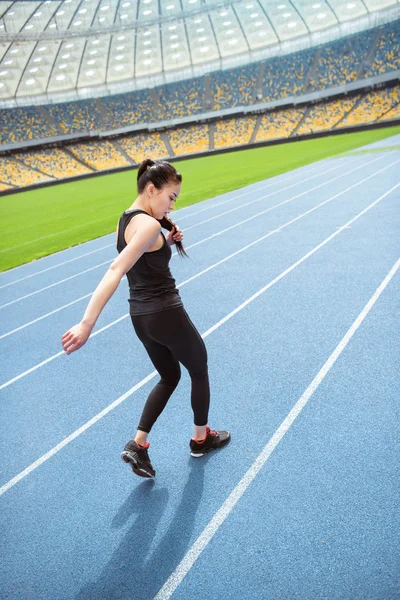 Sportswoman running on stadium — Stock Photo