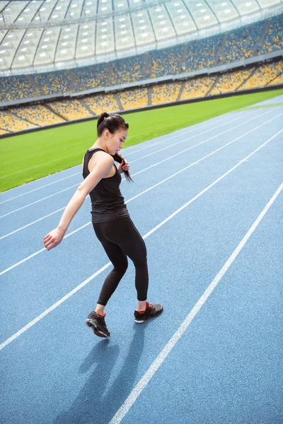 Sportlerin läuft auf Stadion zu — Stockfoto