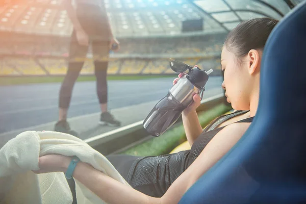 Sportswomen resting on stadium — Stock Photo