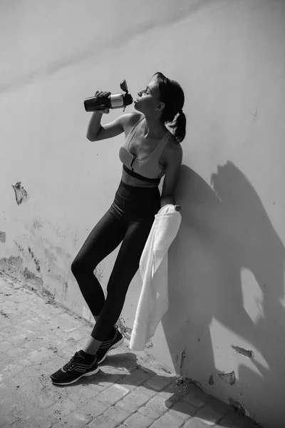 Sportswoman drinking water — Stock Photo
