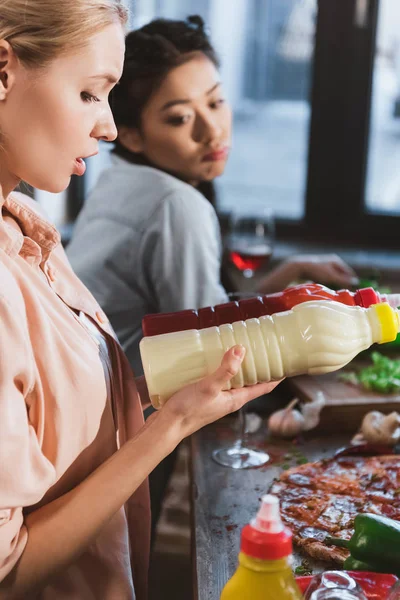 Young woman chosing sauce — Stock Photo