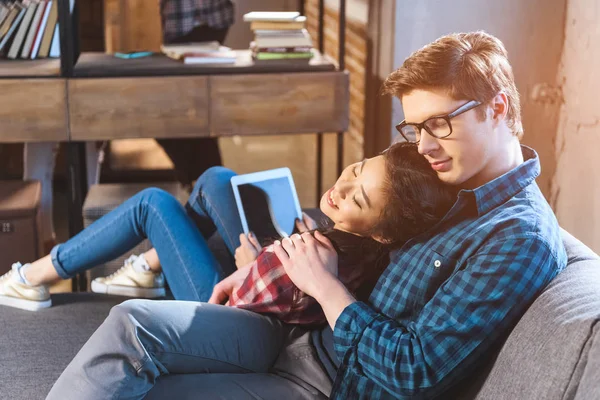 Couple resting on sofa, using tablet — Stock Photo