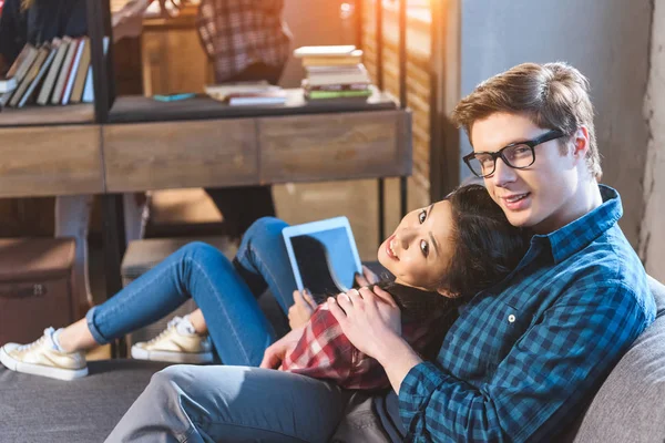 Coppia appoggiata sul divano, utilizzando tablet — Foto stock