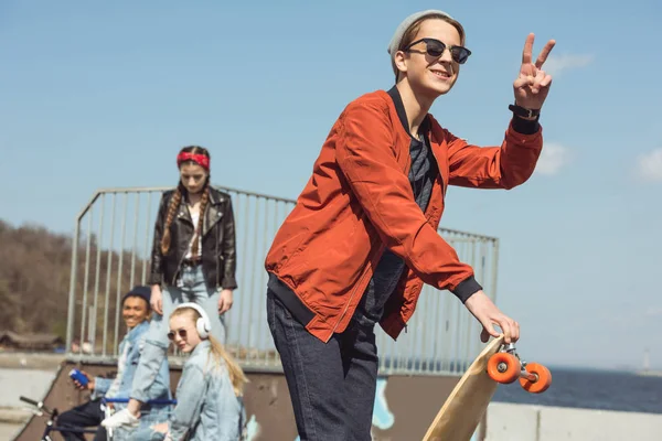 Adolescente con patín en el parque de skate - foto de stock