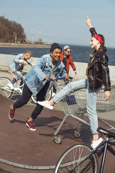 Teenagers with shopping cart and bicycle — Stock Photo