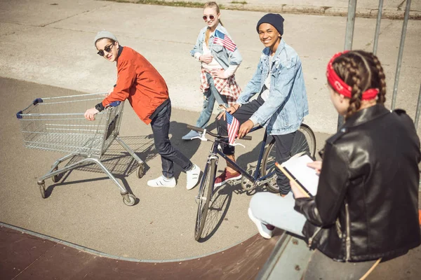 Adolescentes com carrinho de compras e bicicleta — Fotografia de Stock