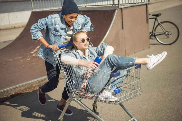 Teenagers having fun with shopping cart — Stock Photo