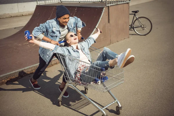 Teenagers having fun with shopping cart — Stock Photo