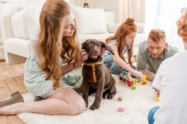 Famille jouer avec chiot — Photo de stock