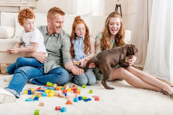 Família brincando com filhote de cachorro — Fotografia de Stock