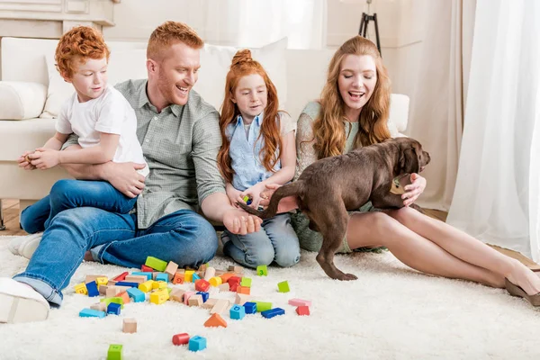 Famille jouer avec chiot — Photo de stock