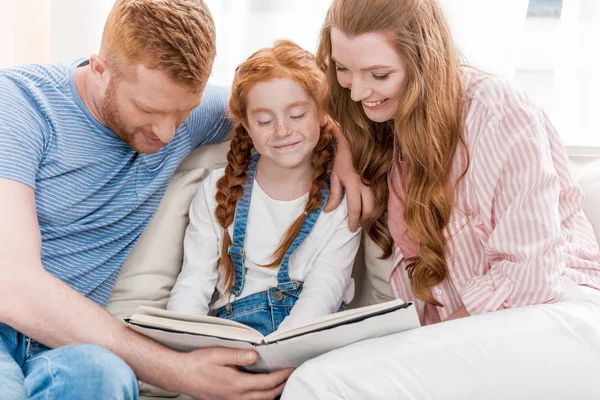 Parents with daughter reading book — Stock Photo