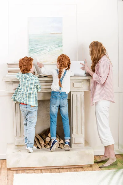 Madre con niños leyendo libros - foto de stock