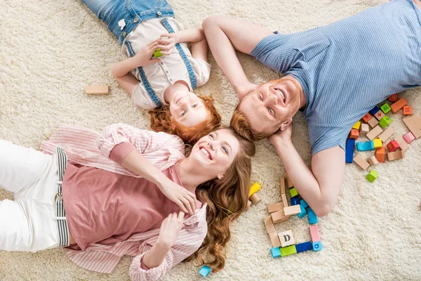 Happy family lying on floor — Stock Photo