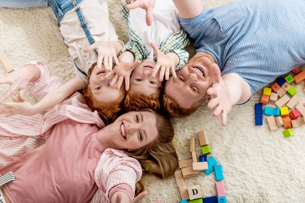 Familia feliz tendida en el suelo - foto de stock