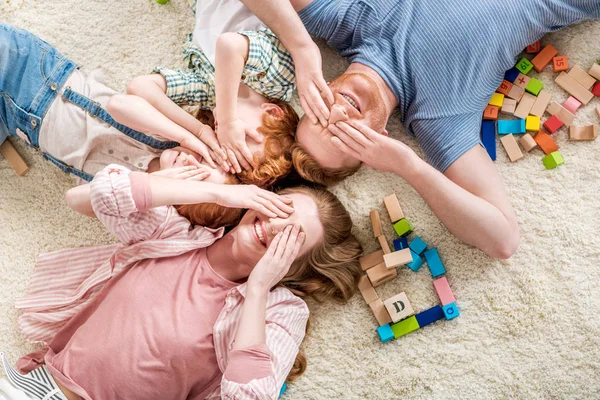 Familia feliz tendida en el suelo - foto de stock