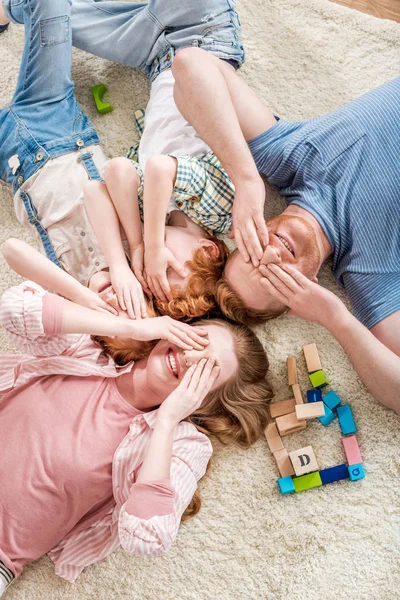 Famiglia felice sdraiata sul pavimento — Foto stock