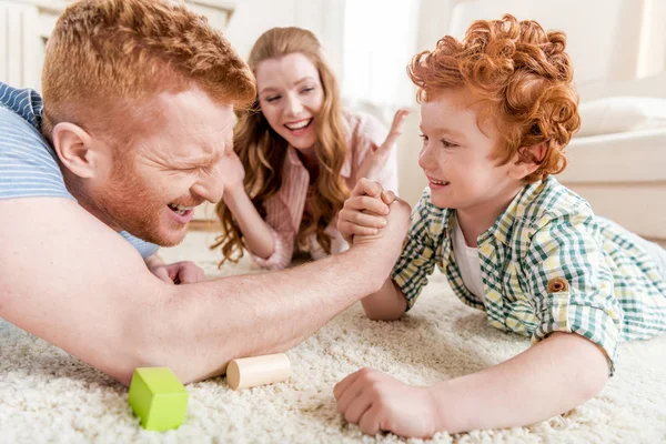 Padre e hijo jugando lucha libre de brazos - foto de stock