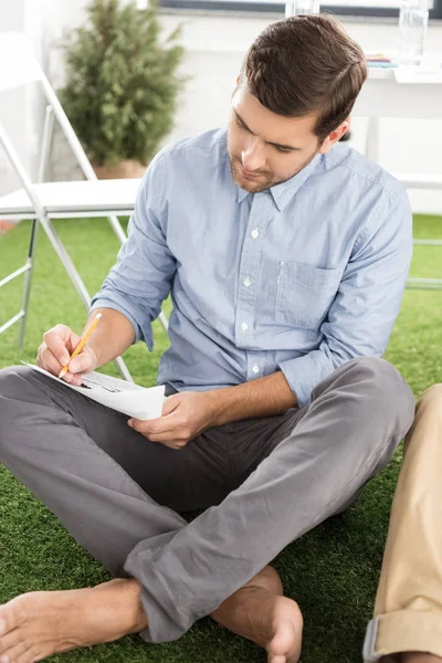 Empresario escribiendo en papel - foto de stock