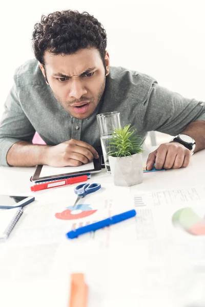 Tired businessman sitting at table in office — Stock Photo