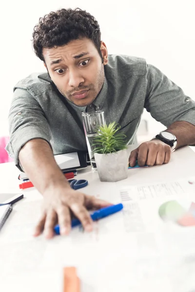 Hombre de negocios cansado sentado en la mesa en la oficina - foto de stock